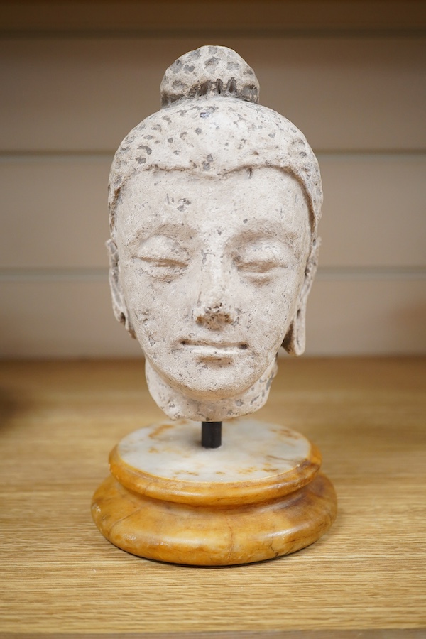 A stucco work head of Buddha, on marble stand, 21cm. Condition - fair